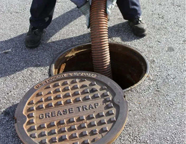 A technician pumping a commercial grease trap